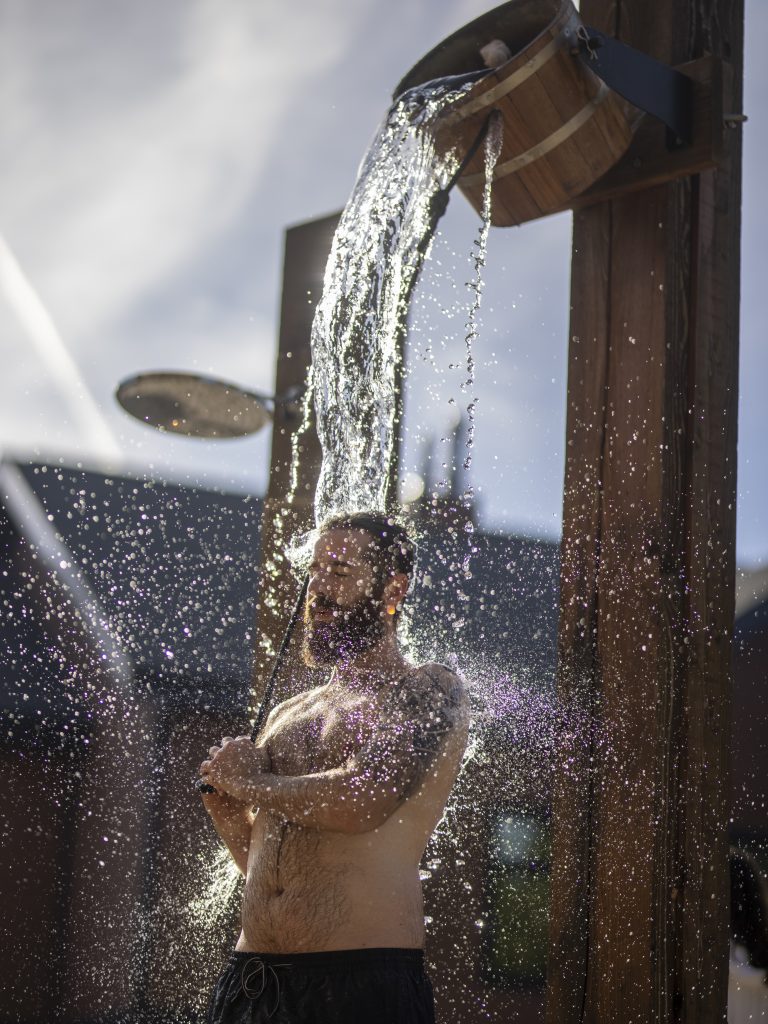 man pouring a bucket of cold water on himself