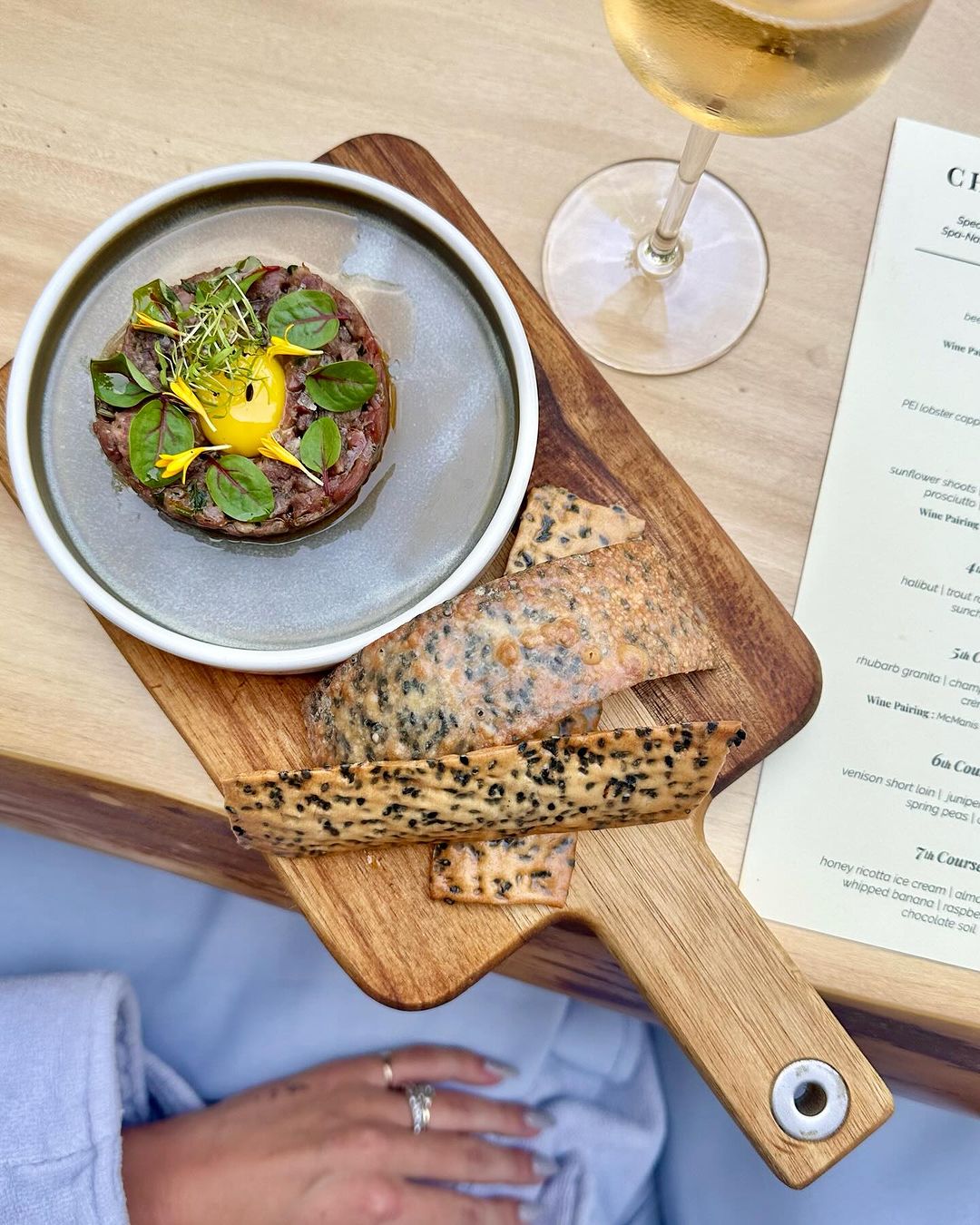 beef tenderloin tartar with a quail egg, chili oil and sesame cracker